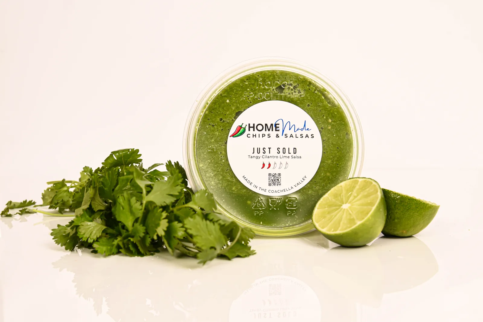 A tub of Just Sold salsa with its fresh ingredients