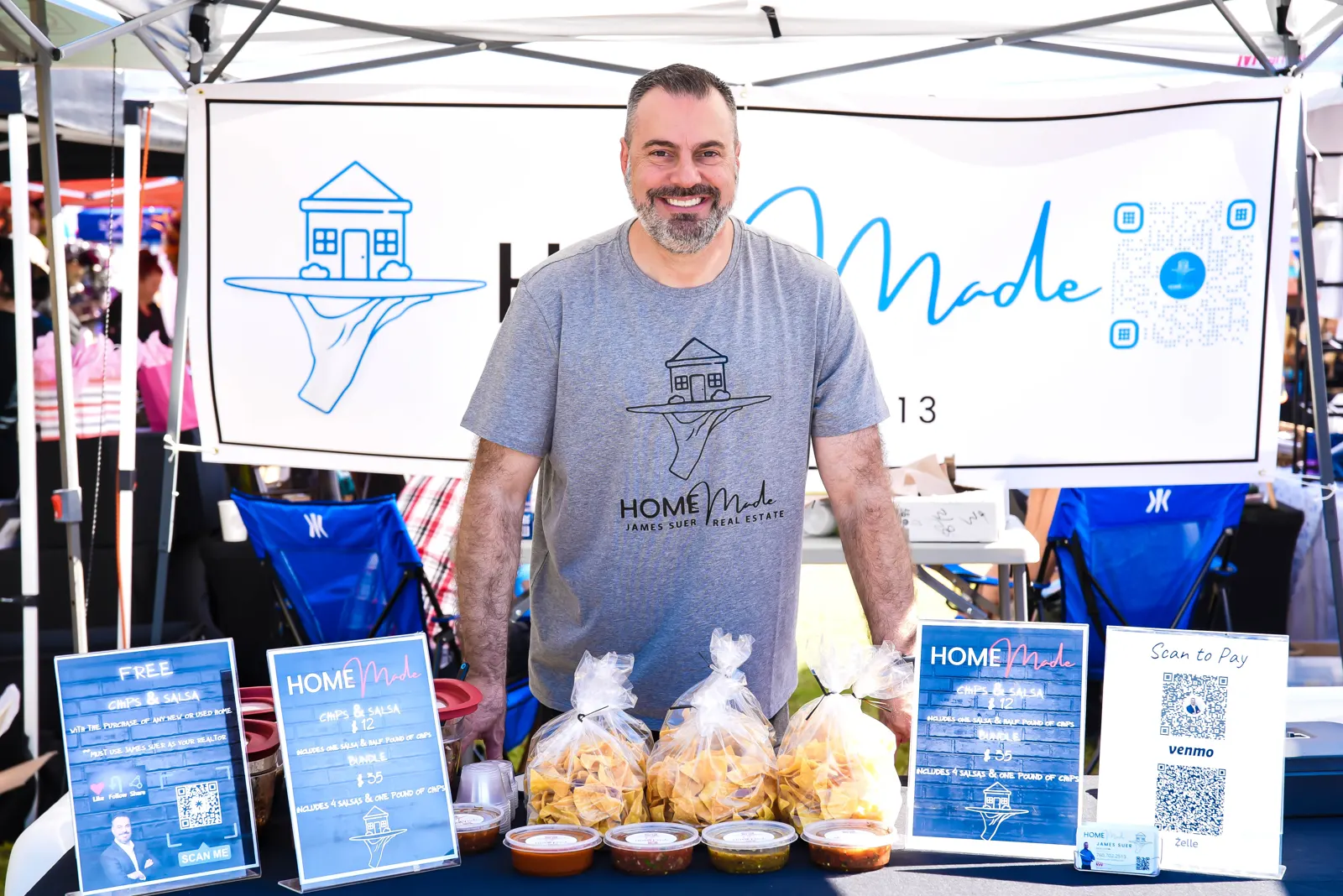 James smiling behind the HOMEmade booth with chips and menu signs